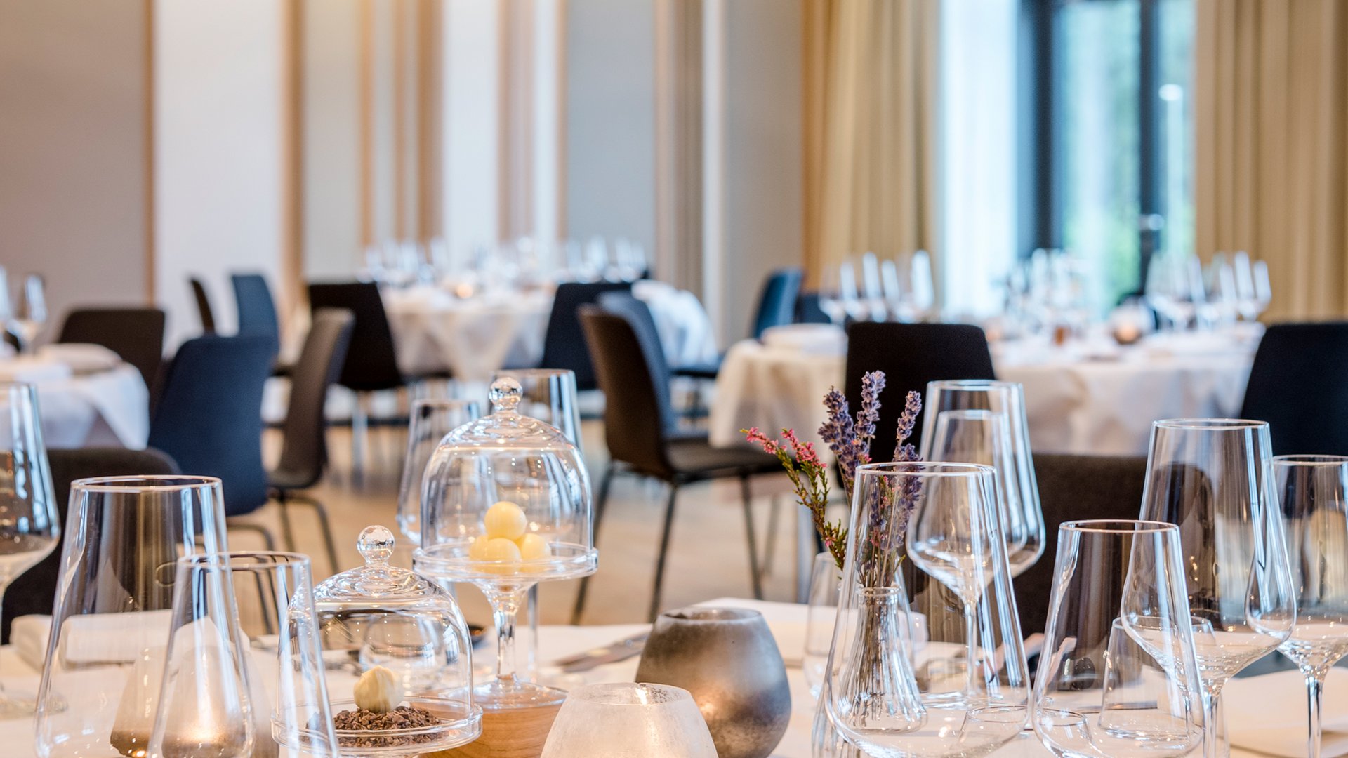 Elegant gedeckter Tisch in modernem Restaurant mit Kerzen und Glaswaren