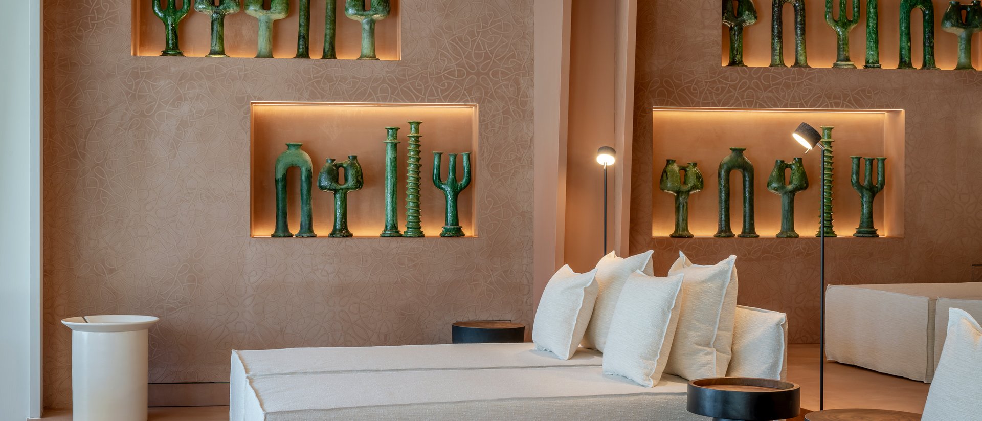 Modern lounge with white sofas and green sculptures on the wall