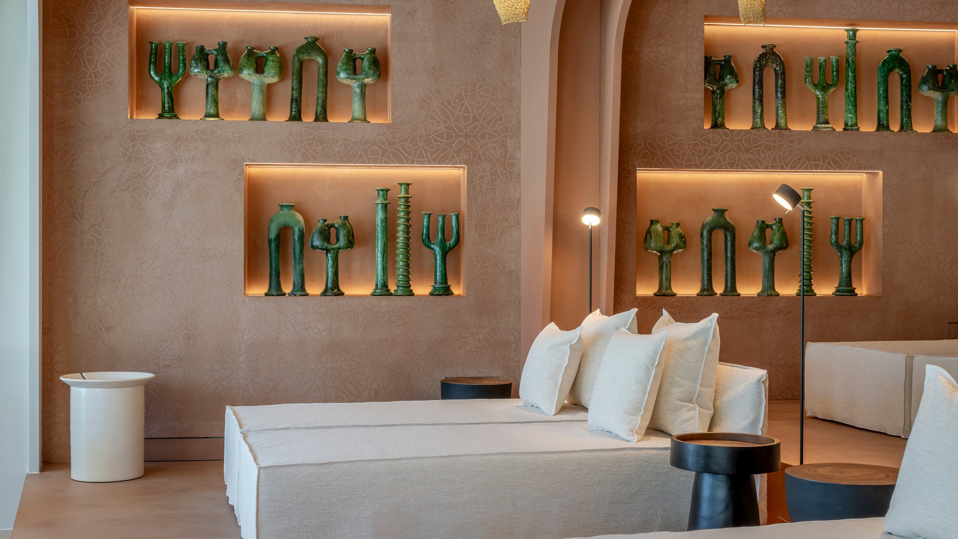 Modern lounge with white sofas and green sculptures on the wall